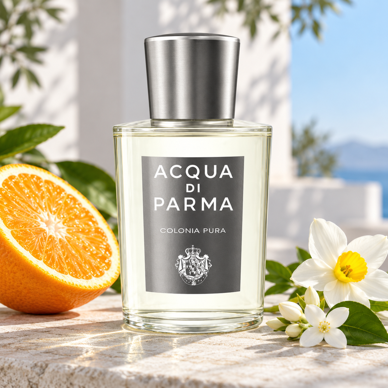 Acqua di Parma Colonia Pura bottle on sunlit limestone beside an orange half, jasmine, and narcissus against a bright white and blue backdrop.