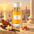 Boucheron Ambre d’Alexandrie with tobacco leaf, vanilla orchid and pods, and resin on a stone ledge overlooking a golden harbor.
