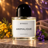 yredo Animalique on warm gray stone beside yellow mimosa, purple violets, and folded taupe suede, with amber and violet disco reflections behind.
