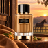 Carolina Herrera Stallion Leather Suede beside tan suede, osmanthus blossoms, and cardamom, with a horse softly blurred against the sunset.