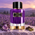 Carolina Herrera Amethyst Haze beside lavender, an amethyst crystal, coffee beans, and cardamom on pale stone overlooking lavender fields at sunset.