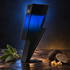 Carolina Herrera Bad Boy Cobalt Elixir’s blue-to-black lightning-bolt bottle beside sage, sliced black truffle, and frankincense resin under blue and amber light.