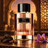 Carolina Herrera Bronze Tonka beside tonka beans, roasted coffee, and a saffron crocus, framed by an amber-lit arch and geometric lattice.