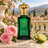 Clive Christian 1872 for Women with pink roses, lily of the valley, and bergamot on a sunlit stone terrace overlooking a rose garden.