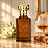 Clive Christian C for Women with white tuberose, cognac, and sandalwood on marble in warm afternoon light.