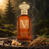 Clive Christian V Amber Fougere bottle on dark stone beside peppercorns, frankincense resin, and vetiver roots, with softly blurred trees and drifting smoke.