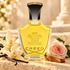 Creed Vanisia perfume on cream stone beside vanilla orchids, a blush rose, and sandalwood in warm golden light.