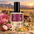 D.S. & Durga Cowgirl Grass perfume stands in a flowering Western prairie at sunset, surrounded by peonies, geraniums, jasmine, lychee, bergamot, amber crystals, and a jeweled cowgirl belt.