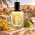 Diptyque Eau Nabati bottle with immortelle flowers and a whole bergamot on sandy stone beside a sunlit oasis.