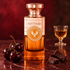 Electimuss Caspian Cherry beside black cherries and dark chocolate on burgundy marble, with a softly blurred glass of amaretto behind.