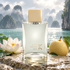 Ella K Pluie sur Ha Long perfume beside a lotus flower and whole pear on wet stone overlooking a misty turquoise bay.