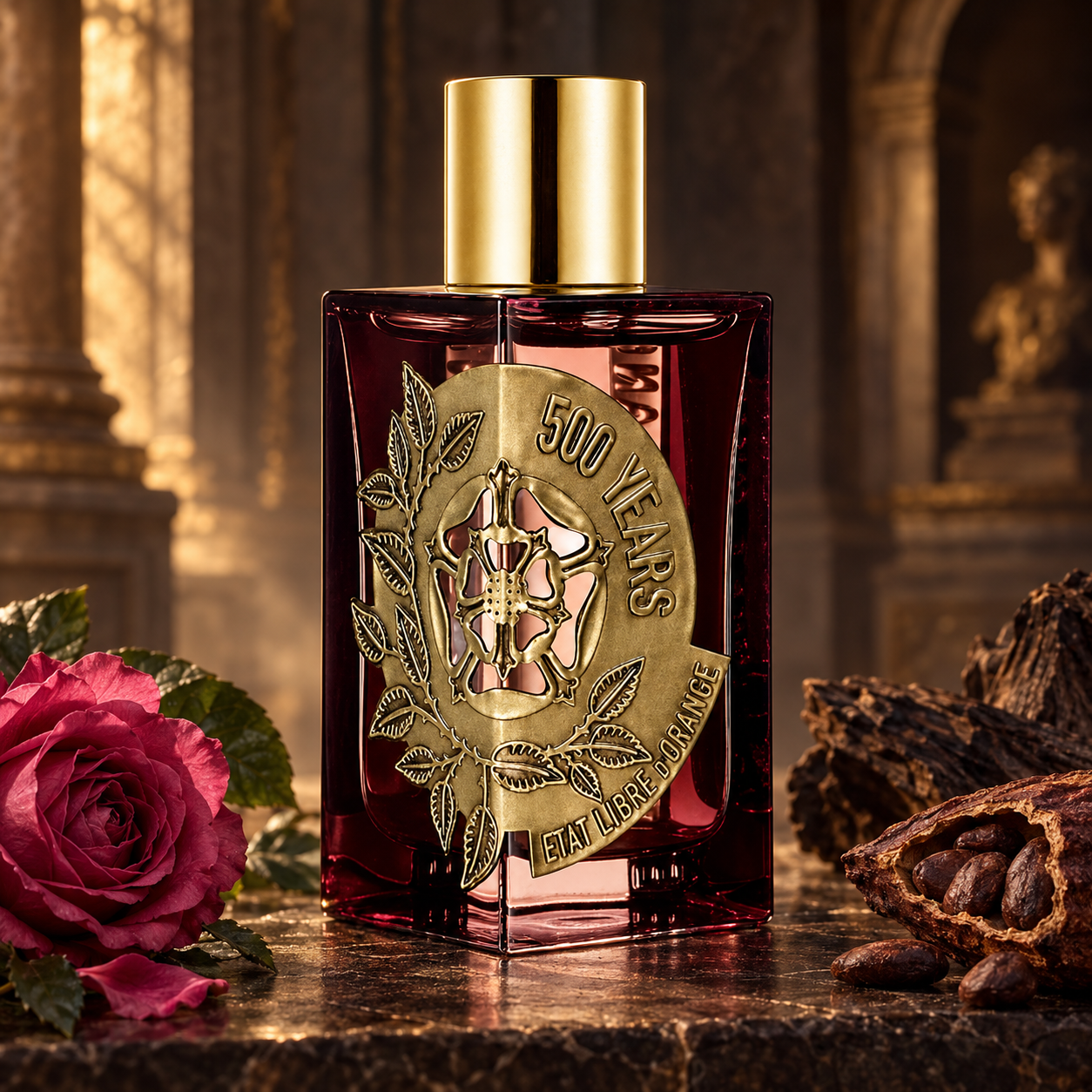 État Libre d’Orange 500 Years bottle beside a rose, cacao pod, and dark wood in a warmly lit stone interior.