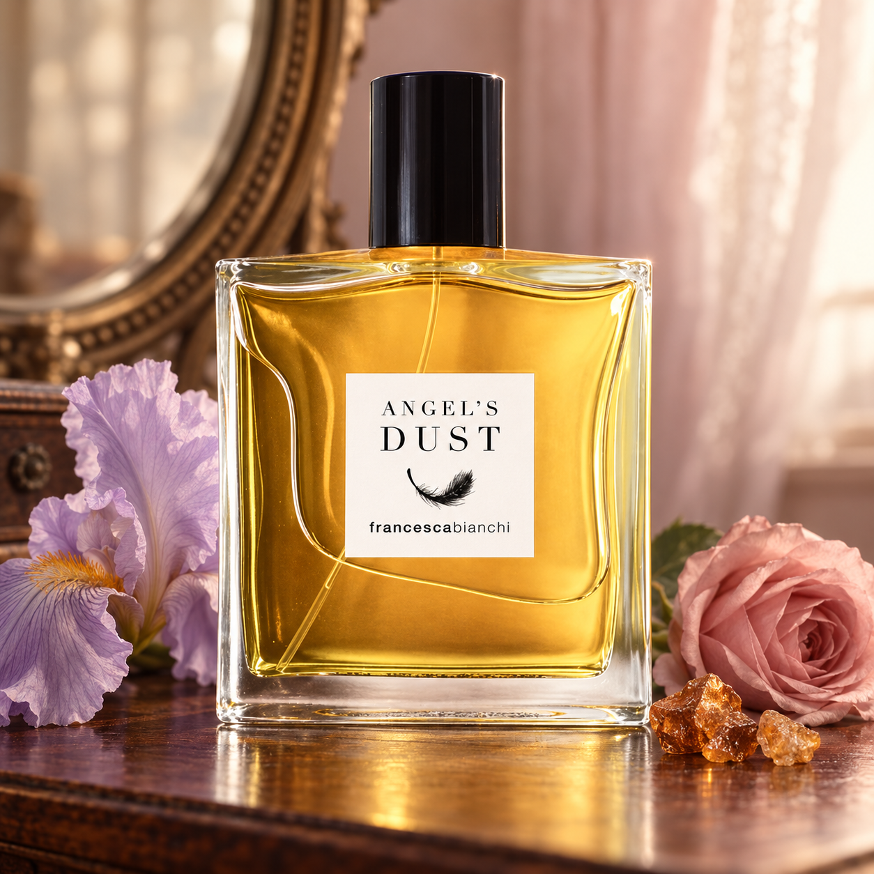 Francesca Bianchi Angel’s Dust on a walnut dressing table beside lilac iris, a dusty-pink rose, and amber resin, with an antique mirror in soft warm light.