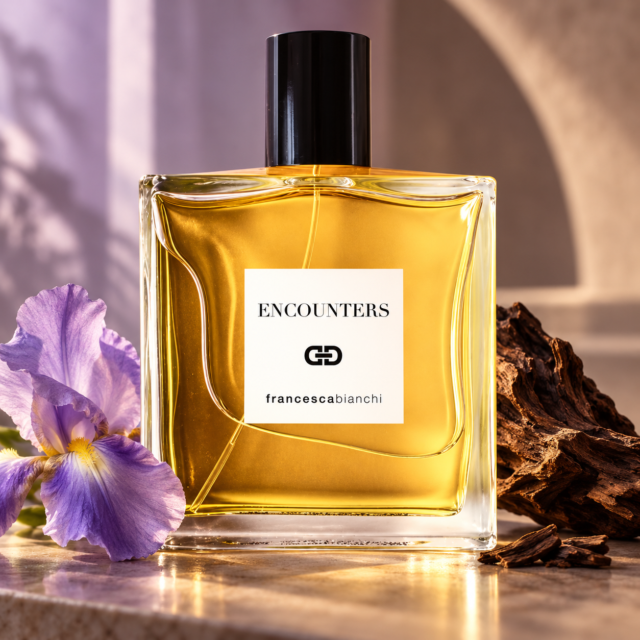 Francesca Bianchi Encounters bottle beside purple iris and oud wood on pale stone in warm, soft light.