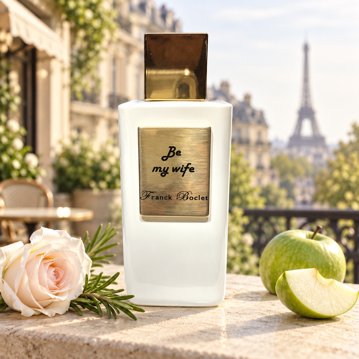 Franck Boclet Be My Wife on a sunlit Paris terrace beside a blush rose, rosemary, and green apple, with the Eiffel Tower softly blurred behind it.