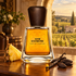Frapin 1270 Extrême bottle with pineapple, vanilla pods, and tonka beans on a wooden table overlooking a sunlit vineyard.