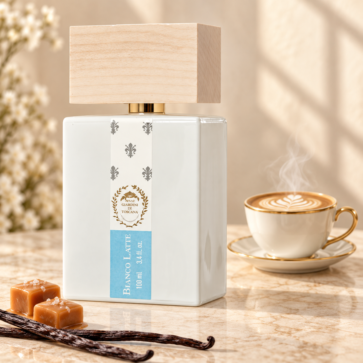 Bianco Latte bottle in sharp foreground focus, with caramel, vanilla pods and a smaller gold-rimmed latte cup behind it.