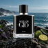 Giorgio Armani Acqua di Giò Elixir on wet coastal rock beside violet leaves, green citrus, and dark leather, with a softly blurred ocean behind it.