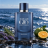 Giorgio Armani Acqua di Giò Profondo on wet coastal rocks beside rosemary, lavender, and green mandarin, with a sunlit blue sea behind it.