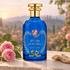 Gucci A Song for the Rose beside pink roses and pale wood on limestone, with a softly blurred garden at sunrise.