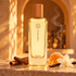 Ambre Narguilé with cinnamon, honeycomb, and a white orchid in a golden alcove with a delicate curl of smoke.