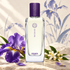 Hermès Iris Ukiyoé on pale stone with purple iris and orange blossoms before a softly painted iris backdrop.