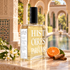 Histoires de Parfums 1826 with white blossoms, tangerine, and cinnamon on marble in a sunlit Andalusian-style courtyard