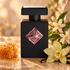 Initio Addictive Vibration beside golden honeycomb, white orange blossoms, and a creamy orchid on warm stone in golden light.