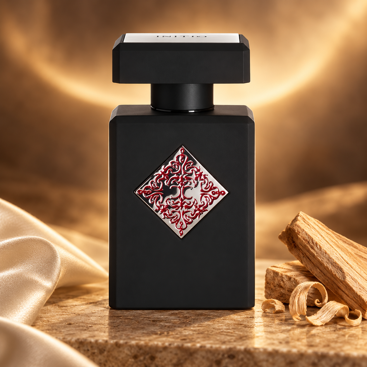 Initio Blessed Baraka bottle with sandalwood and ivory silk on warm stone under golden amber lightin