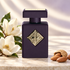 Initio High Frequency bottle with white magnolia blossoms and almonds on ivory stone in soft daylight.