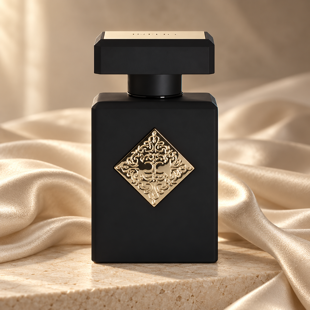 Initio Magnetic Blend 7 on ivory stone, surrounded by champagne silk folds in soft, warm light.