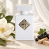Initio Musk Therapy beside white magnolia, blackcurrants, and sandalwood on ivory stone with soft daylight and flowing white fabric.