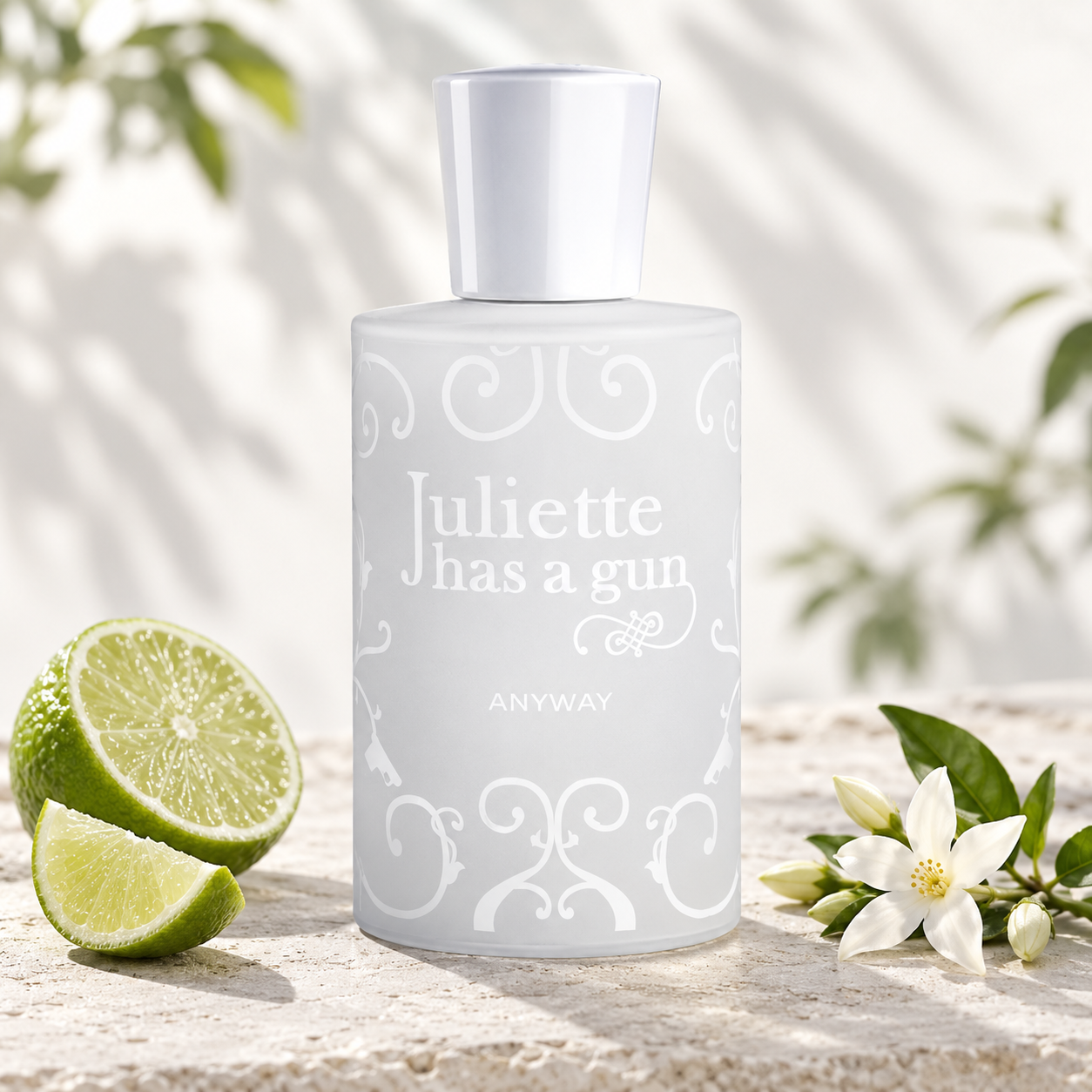 Juliette Has A Gun Anyway beside fresh lime and white blossoms on pale stone, illuminated by soft sunlight and leafy shadows.