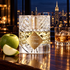 Kilian Apple Brandy on the Rocks on a polished wooden bar beside a green apple and brandy over ice, with the illuminated Manhattan skyline behind it.
