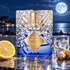 Kilian Blue Moon Ginger Dash beside lemon, ginger, and iced vodka on a coastal terrace beneath a luminous blue moon.