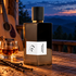 L’Orchestre Parfum Cocktail Appalaches bottle on a wooden porch beside amaretto, vanilla pods, and sesame, with an acoustic guitar and twilight mountains behind.