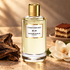 Mancera Crazy For Oud perfume with oud wood, a white magnolia flower, and tiramisu on warm beige stone.
