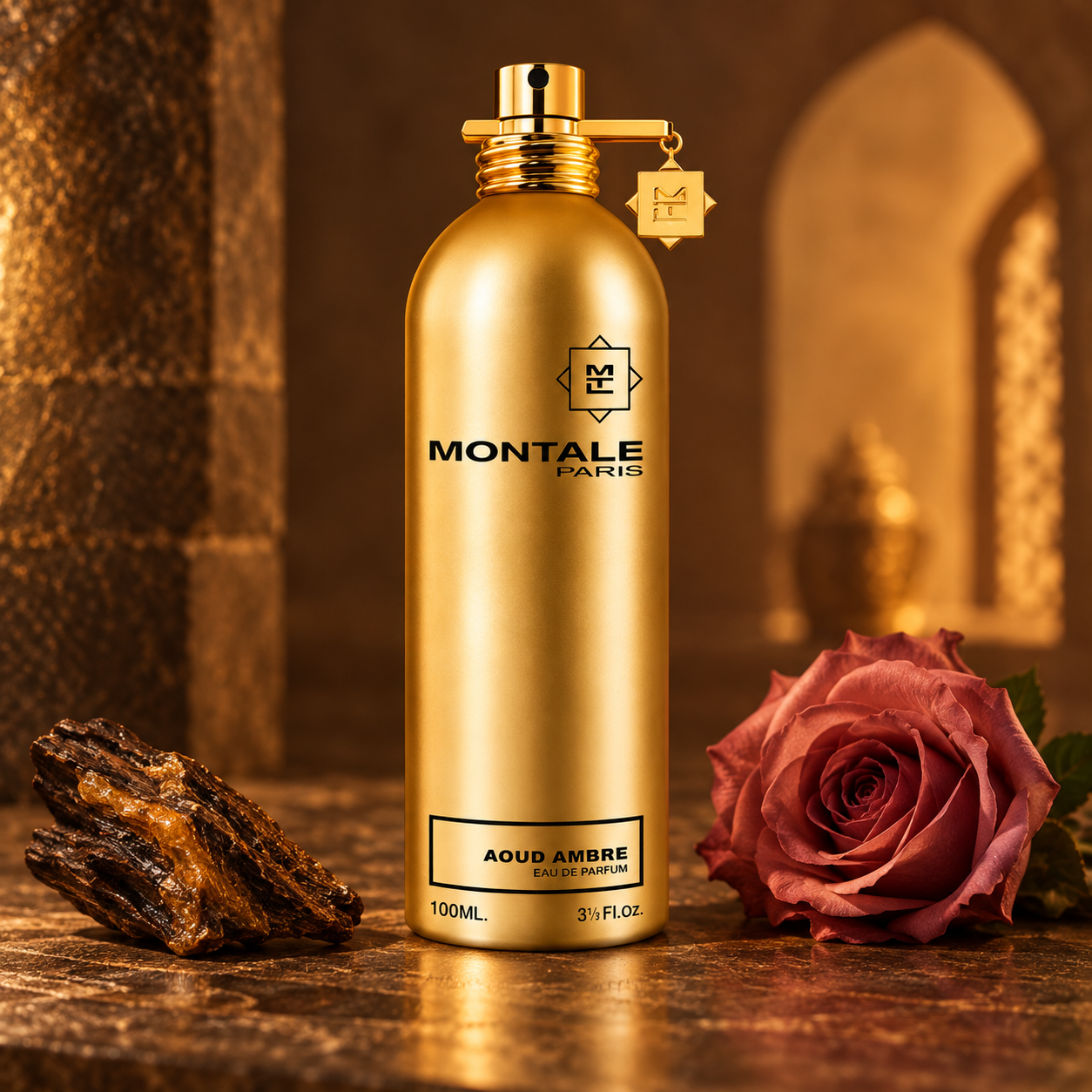 Montale Aoud Ambre’s gold bottle beside a dusty pink rose and oud wood, illuminated by warm amber light against a softly blurred arch.