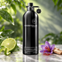 Montale Aromatic Lime on pale stone beside fresh lime, purple saffron crocus, and sandalwood, against softly lit green foliage.