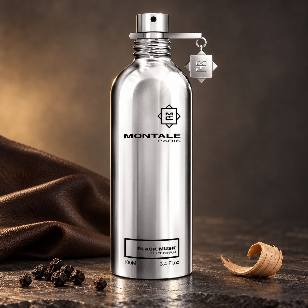Montale Black Musk’s silver bottle beside brown leather, black peppercorns, and a sandalwood curl on dark stone in soft warm light.