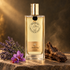 Nicolaï Amber Oud bottle on warm stone beside lavender, purple saffron crocuses, and oud wood in soft golden light.