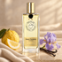 Nicolaï Ambre Cashmere Intense with citron, purple iris, vanilla pods, and cream fabric in soft golden light.