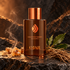 Ojar Eagle Eyed Stranger brown bottle with smoking frankincense, vetiver roots and laurel leaves on warmly lit dark stone.