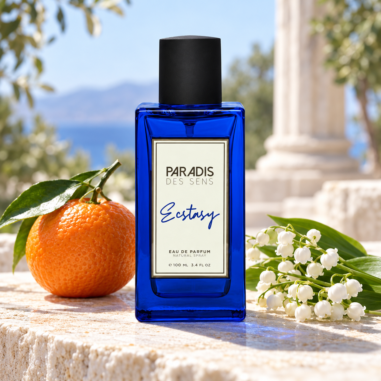 Paradis des Sens Ecstasy blue bottle with a whole mandarin and lily-of-the-valley on sunlit stone beside a softly blurred column.