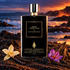 Simone Andreoli Born From Fire on black volcanic sand beside vanilla, saffron crocus, and oud wood, against an amber-lit ocean coastline.