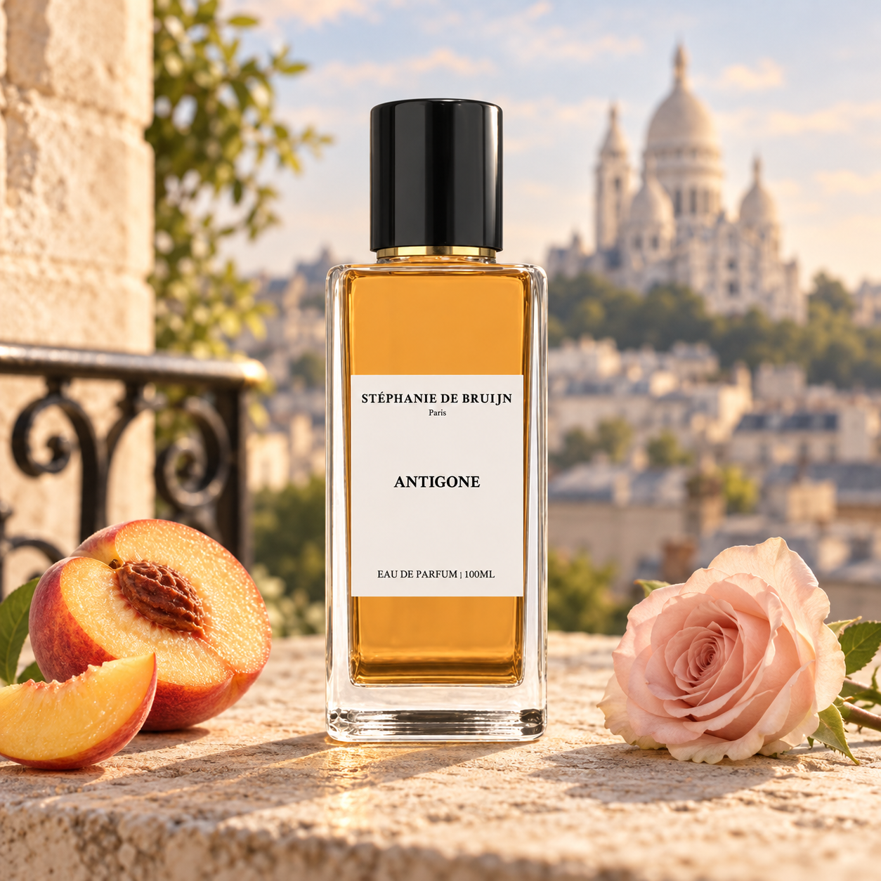 Stéphanie de Bruijn Antigone beside peach and a pale pink rose on sunlit stone, with Sacré-Cœur softly blurred behind it.