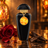 The Merchant of Venice Myrrh Oud black bottle with an orange-gold pendant, surrounded by a red rose, myrrh resin, and oud wood in warm amber light.