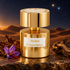 Tiziana Terenzi Arrakis on dark stone beside tobacco leaf, purple saffron crocus, and wood, with amber dunes beneath a star-filled sky.