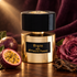 Tiziana Terenzi Bigia beside passion fruit, a dusty rose, and oud wood on dark walnut with plum velvet and warm golden light.