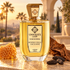 Unique’e Luxury Beverly Hills Exclusive beside honeycomb, tobacco leaf, and tonka beans on a golden-lit terrace with palms and a stucco arch.